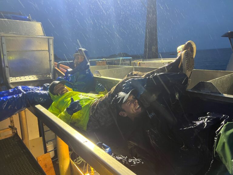 seine fishers resting on deck in rain